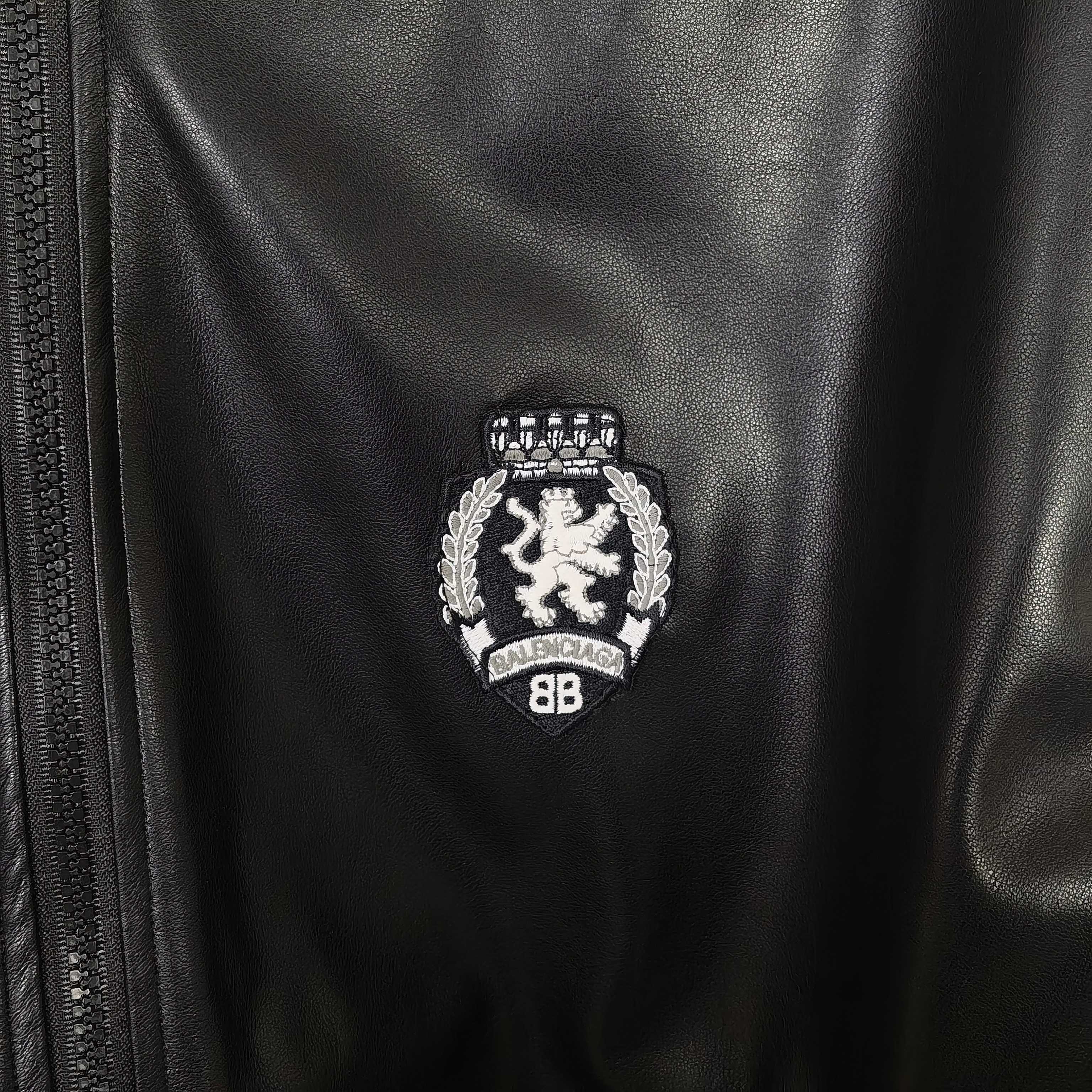 Balenciaga crest emblem on leather bomber jacket near the zipper
