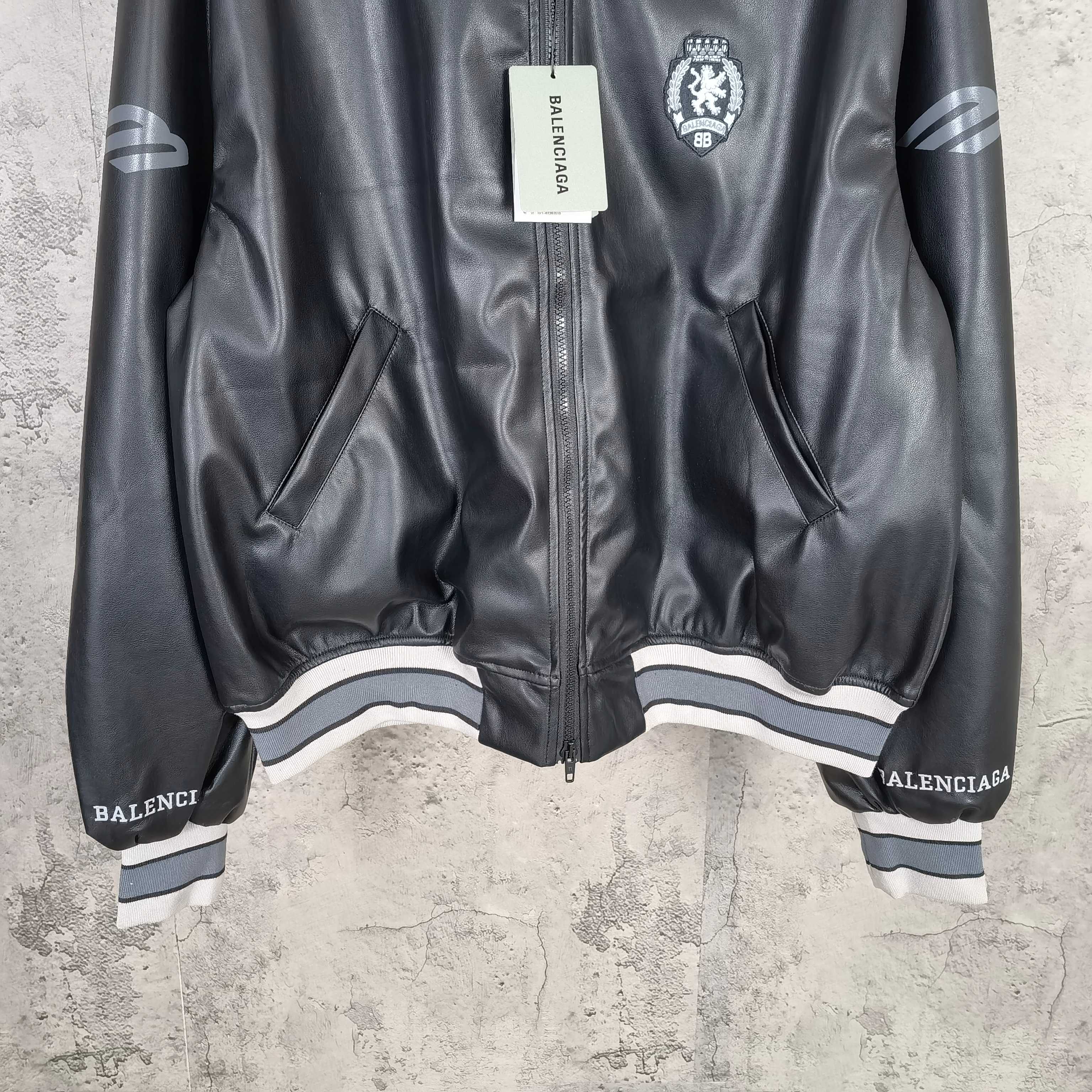 Balenciaga leather bomber jacket hem view with front zipper and striped ribbed cuffs