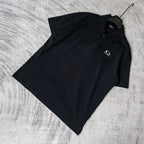 Balenciaga polo shirt, dark color, folded angle view, short sleeves, collar visible