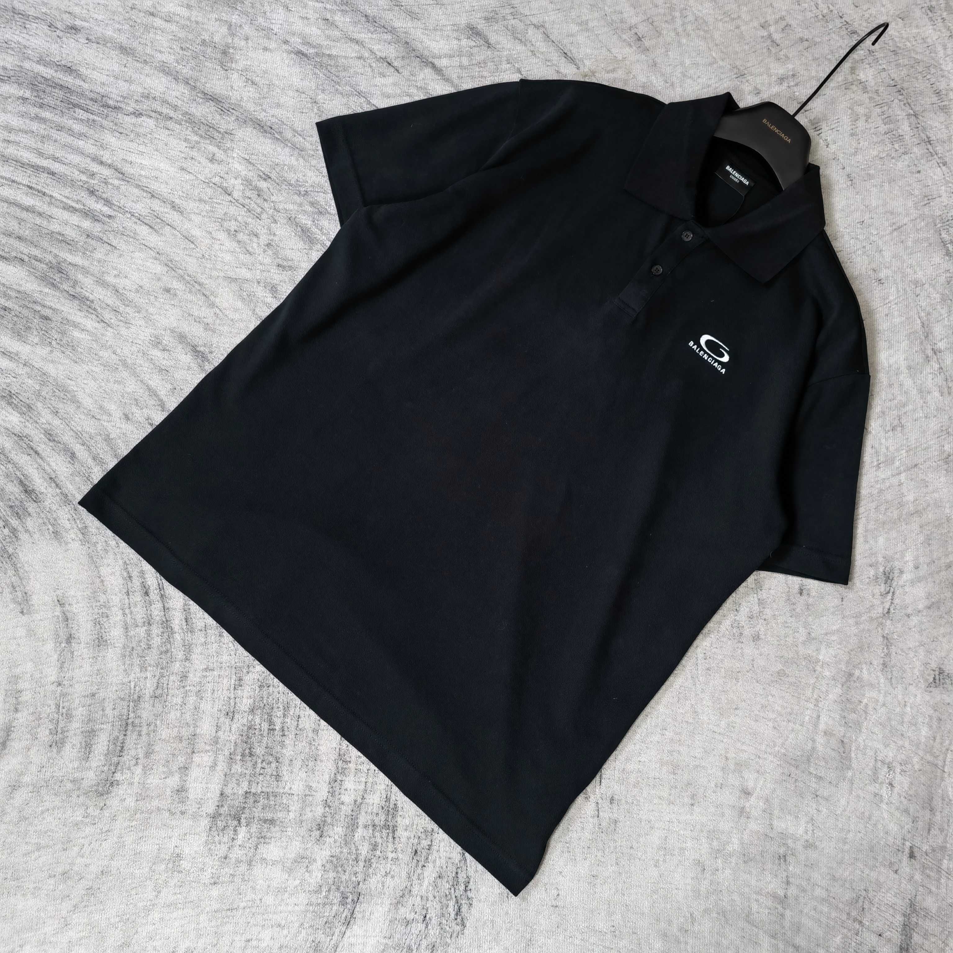 Balenciaga polo shirt, dark color, folded angle view, short sleeves, collar visible