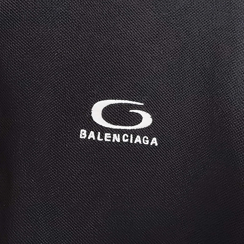 Balenciaga logo on dark textured fabric, polo-style chest emblem