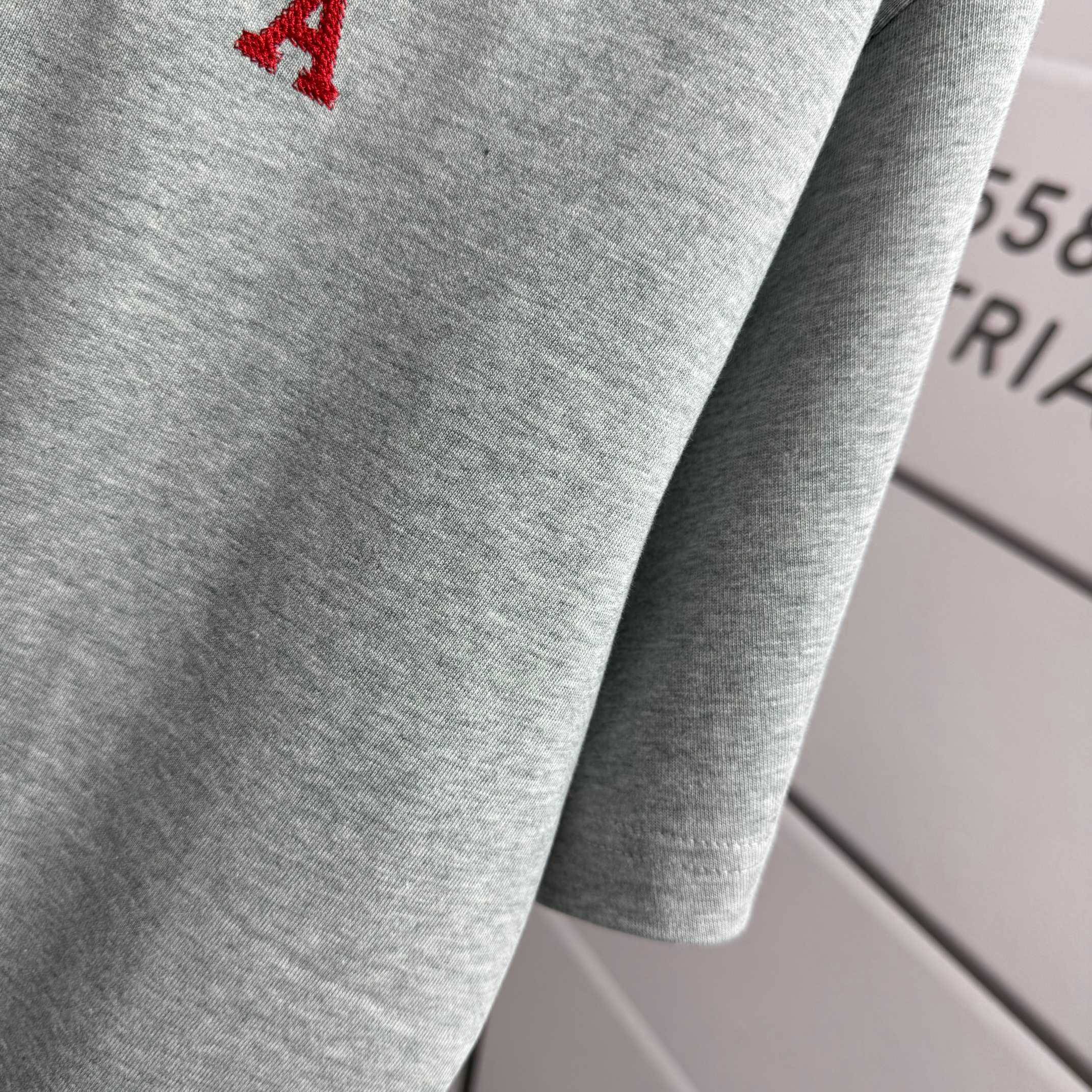 Heather gray T-shirt with red logo on chest, crew neck and short sleeve.