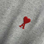 Heather gray T-shirt front with red heart-shaped logo and small red A detail.