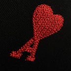 Red heart-shaped logo embroidery on black textured T-shirt fabric