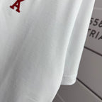 Amiri white T-shirt fabric close-up with partial red heart-and-A logo near shoulder