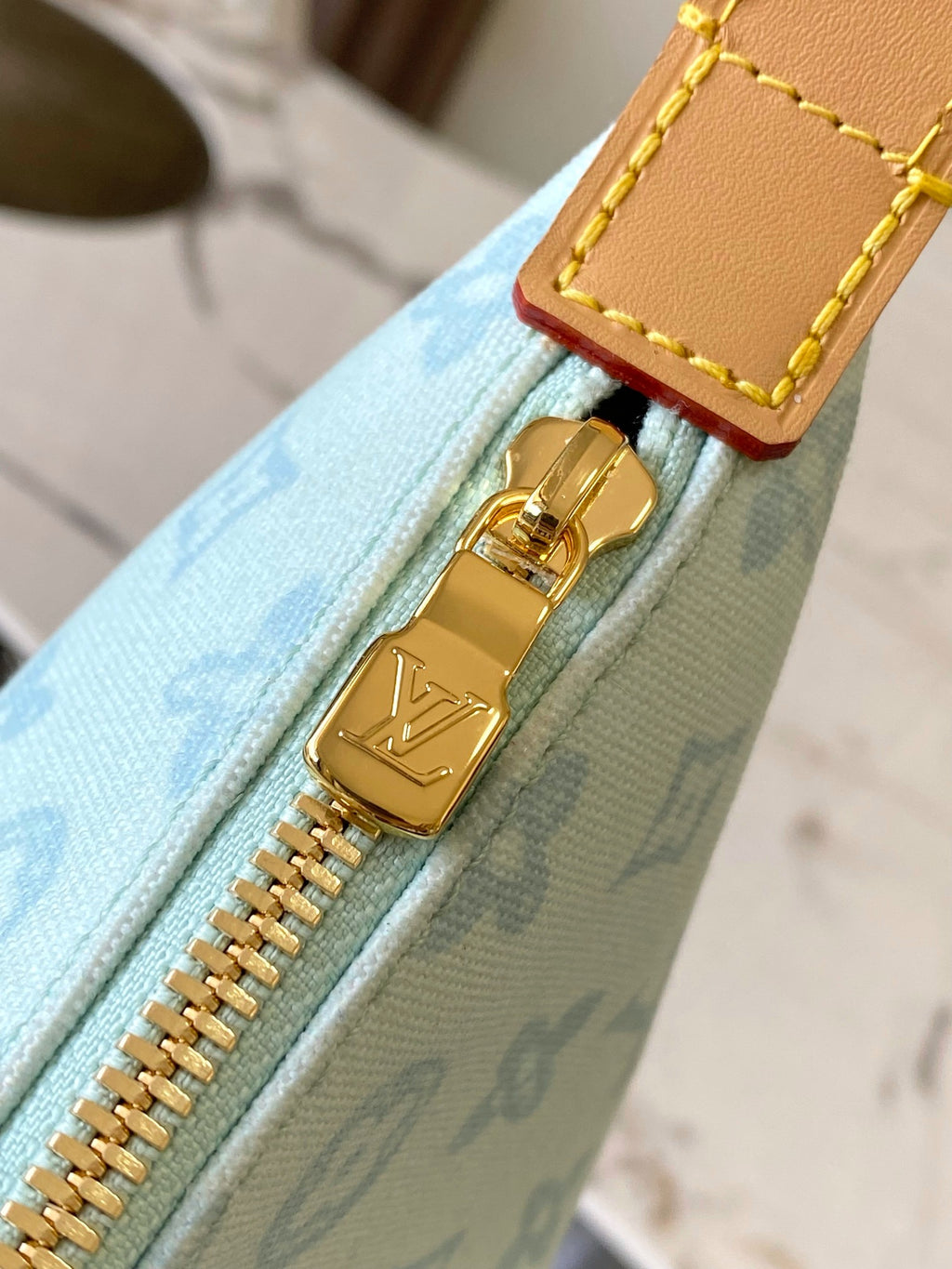 Louis Vuitton gold zipper track and pull detail on light blue monogram bag