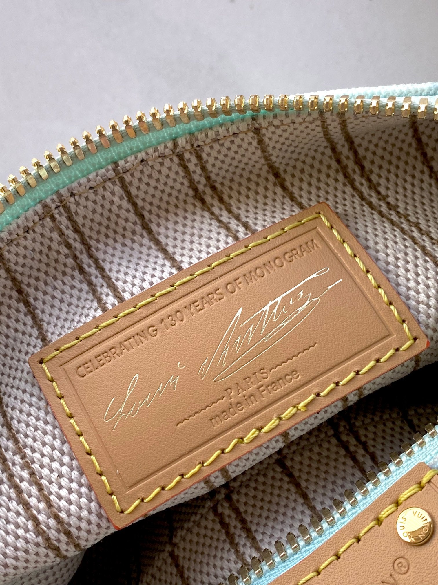 Louis Vuitton light blue monogram bag interior leather tag with gold trim and stitching