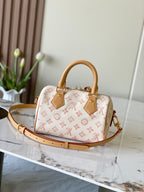 Monogram handbag with tan leather top handles and shoulder strap, gold hardware