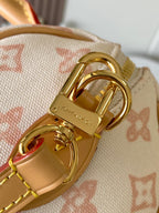 Gold buckle and strap hardware on monogram handbag with tan leather trim