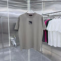 Light gray crewneck T-shirt with navy logo graphic on chest