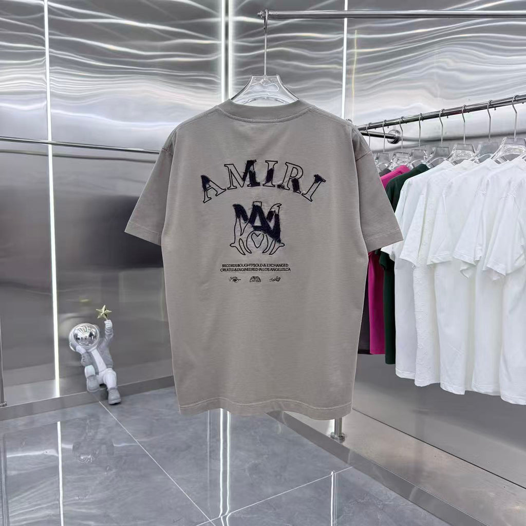 Light gray crewneck T-shirt with navy AMIRI letters logo on chest
