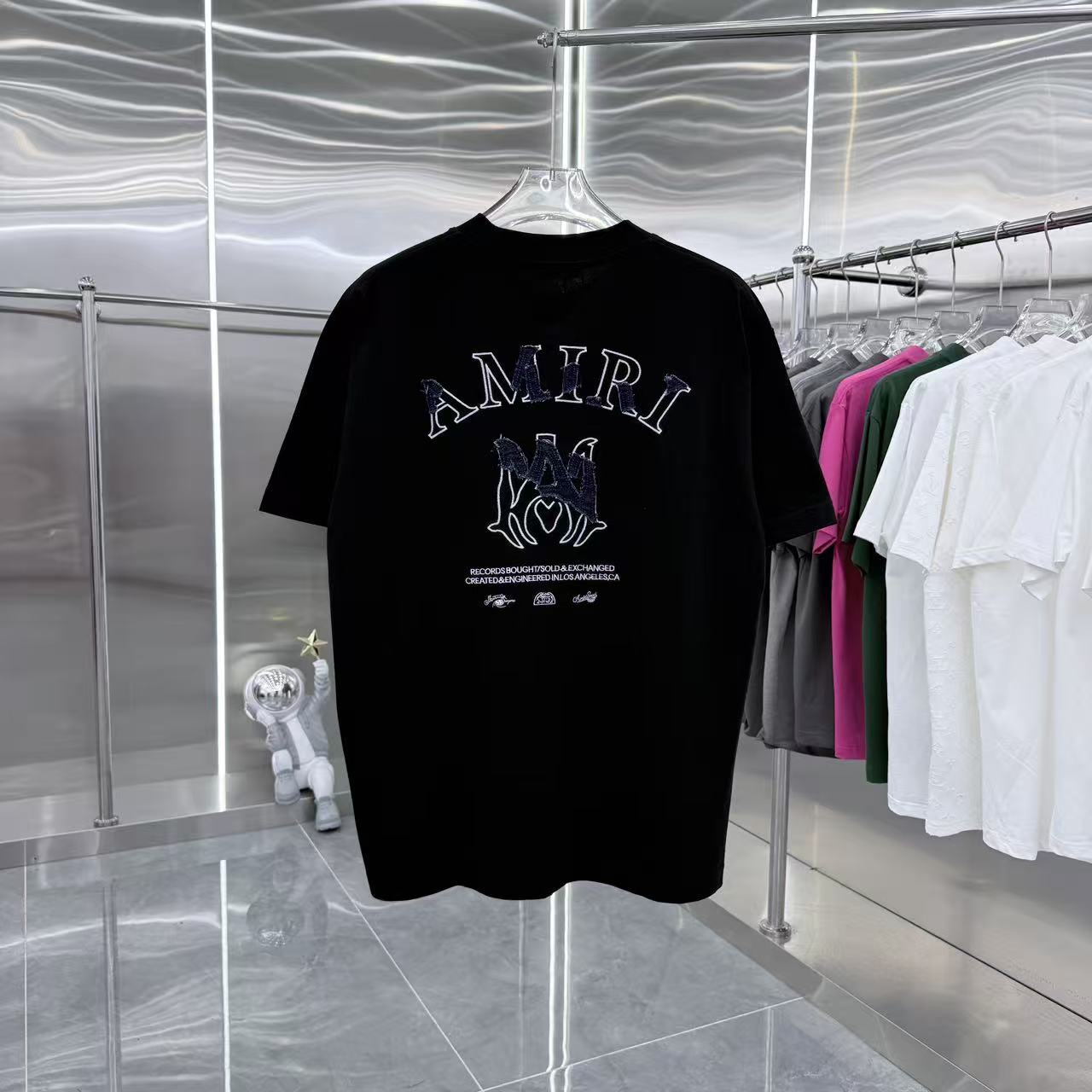 Black crew-neck T-shirt with AMIRI graphic and small text below