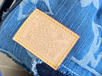 Blue patchwork denim bag with tan leather logo label on a fabric patch