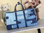 Blue patchwork denim duffel bag with top handles and shoulder strap, gold hardware