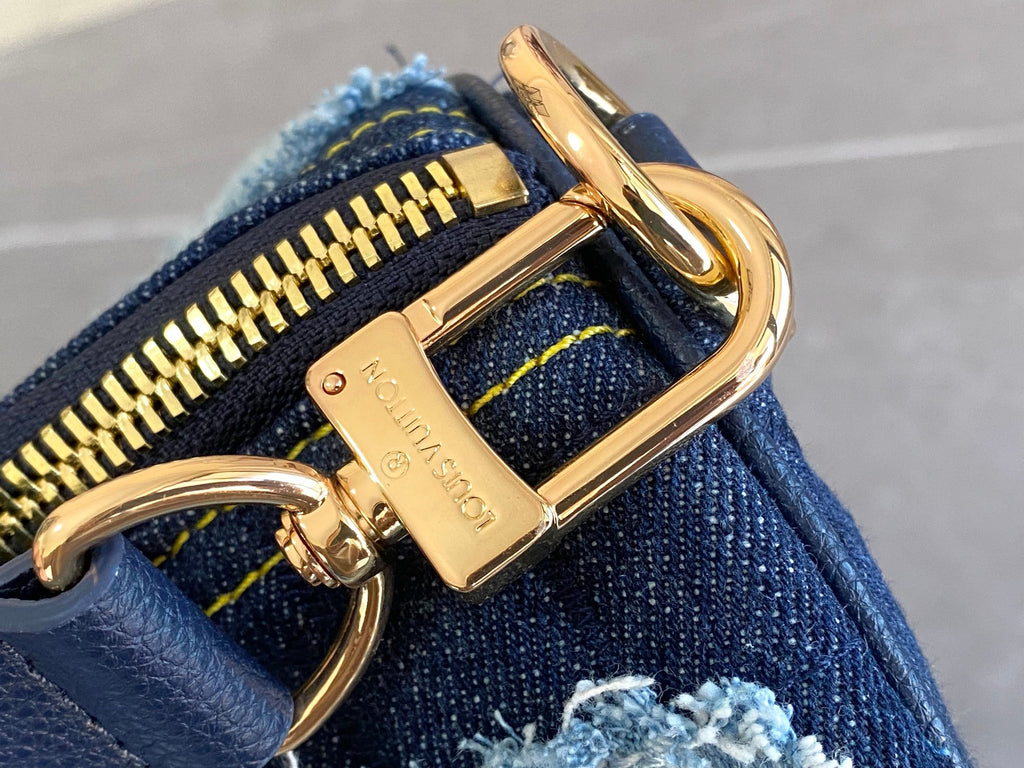 Blue patchwork denim bag close-up of gold ring clasp and zipper pull
