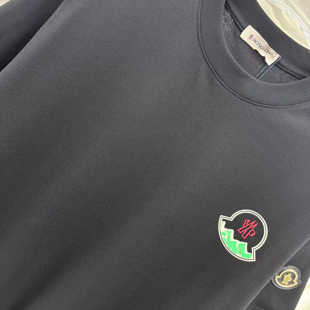 Black short-sleeve T-shirt chest area with crest patch and fabric texture