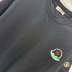 Black short-sleeve T-shirt chest area with crest patch and fabric texture