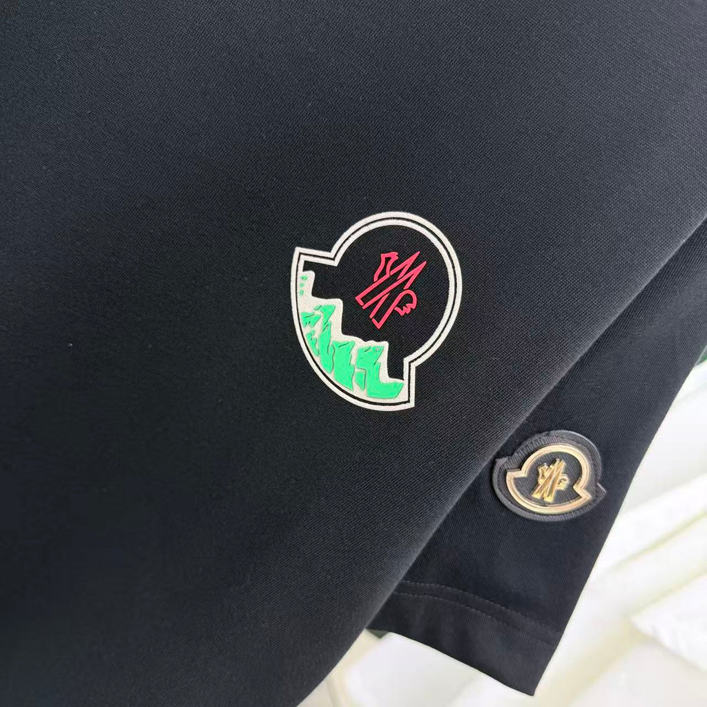 Black short-sleeve T-shirt with large crest patch and smaller round badge