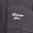 Close-up of dark gray puffer jacket fabric with white Balenciaga Paris chest logo