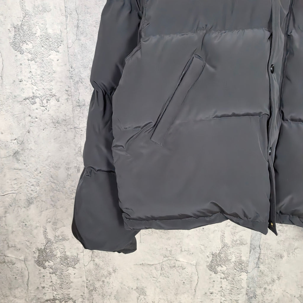 Long puffer jacket in dark gray, front pocket and hem area shown