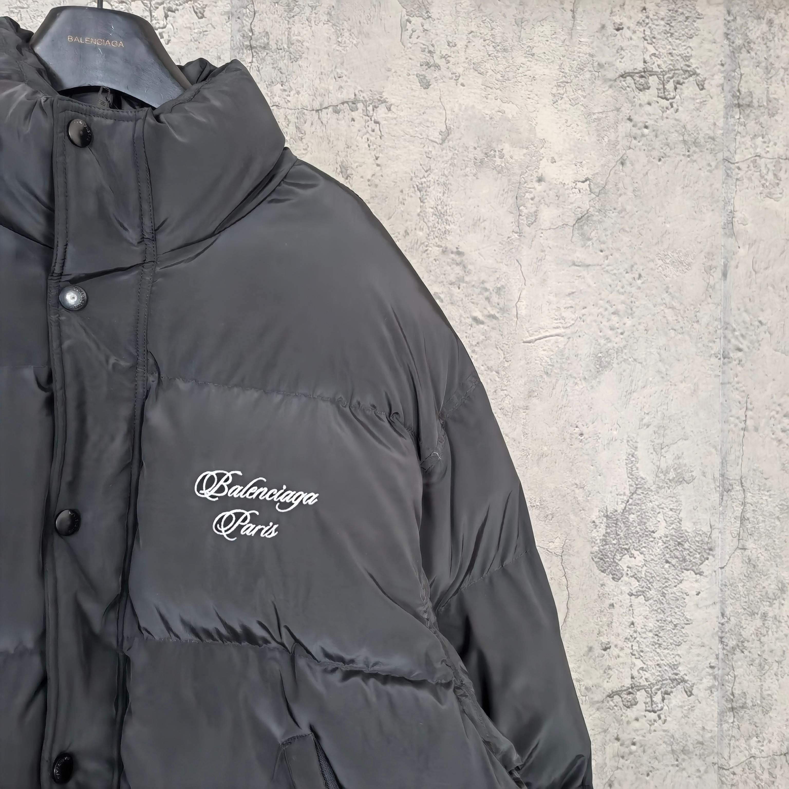 Long hooded puffer jacket in dark gray with white Balenciaga Paris logo on chest