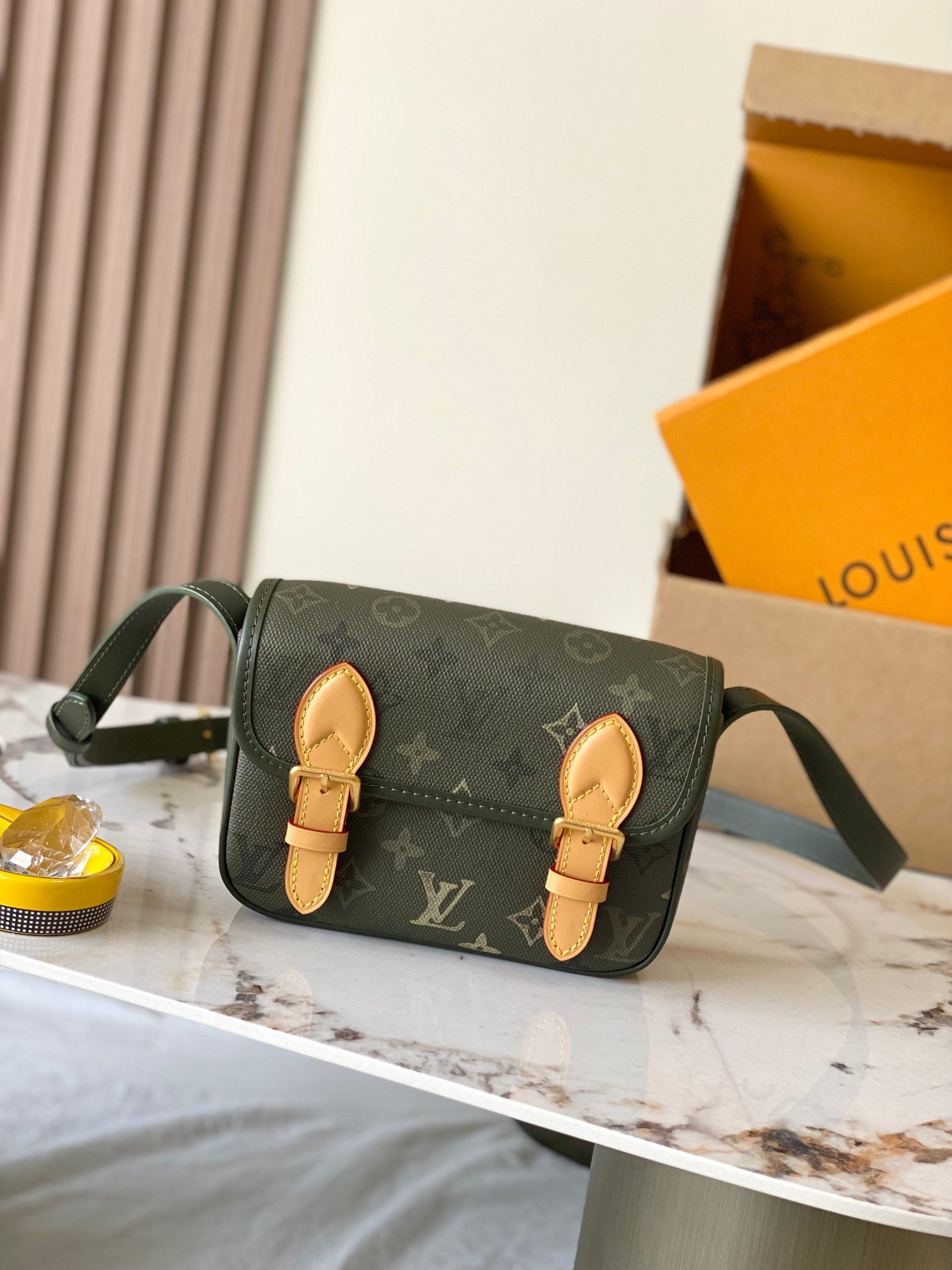 Dark green Louis Vuitton monogram crossbody with flap, tan leather straps, gold hardware.