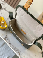 Open dark green Louis Vuitton crossbody showing beige interior lining and inner pocket.