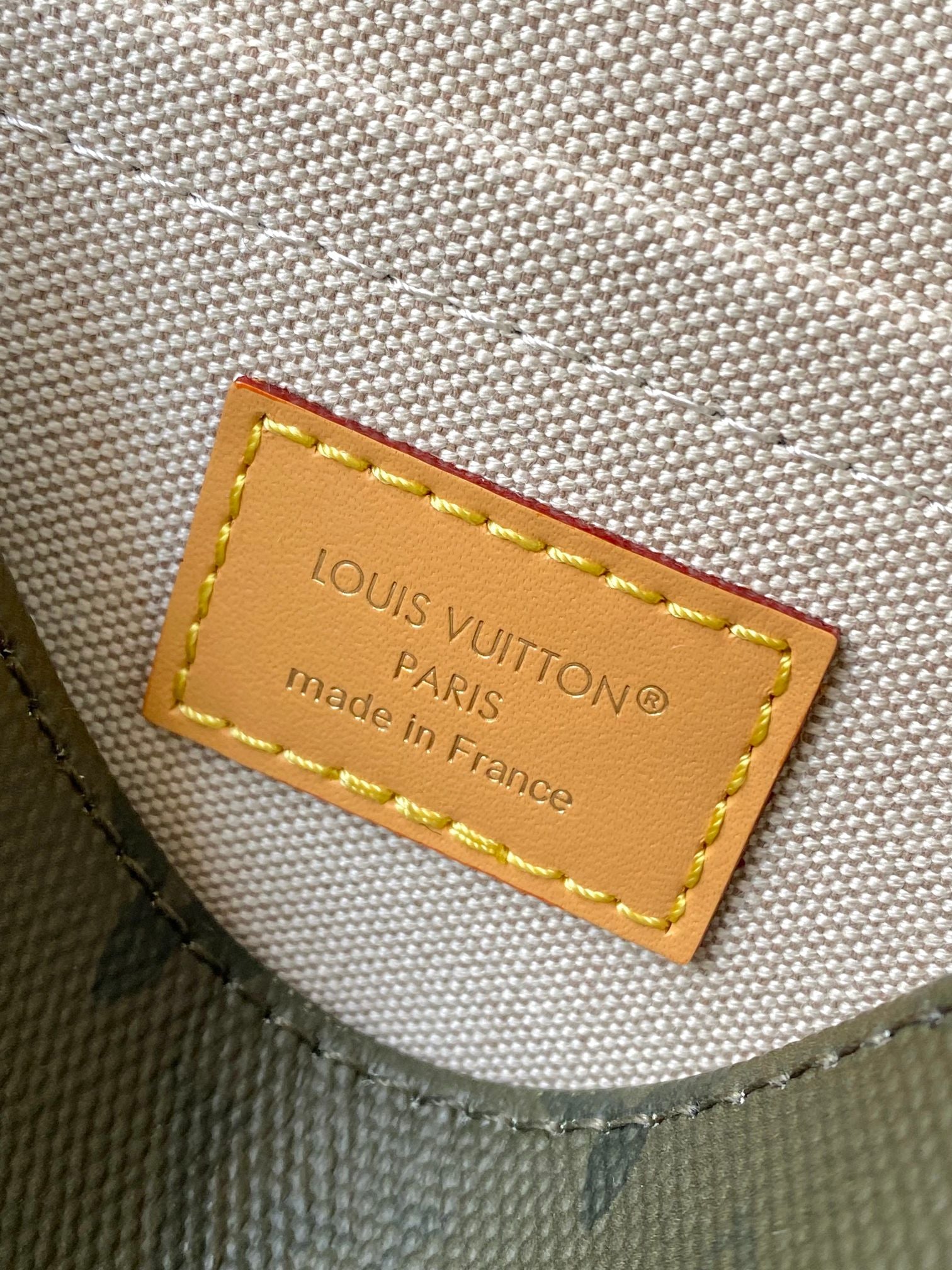 Louis Vuitton label on dark green bag lining: “PARIS” and “made in France” text