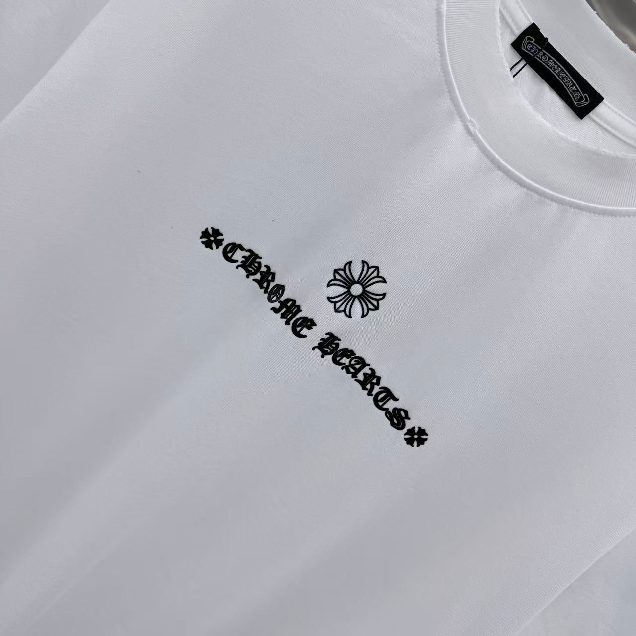 White short-sleeve T-shirt close-up of chest graphic text and flower emblem