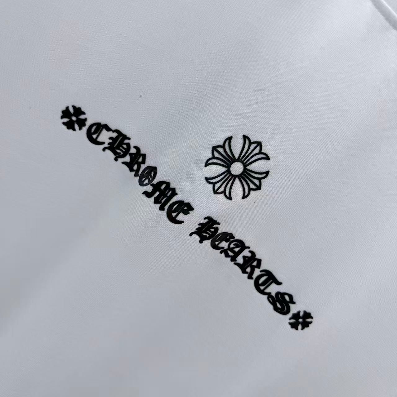 White short-sleeve T-shirt close-up of black graphic text and flower
