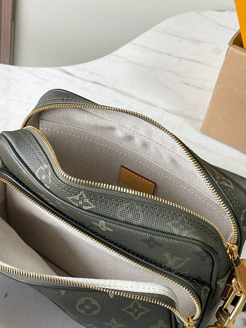 Louis Vuitton crossbody bag open view showing lined interior and zip compartments