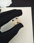 Gold-tone Chanel CC statement ring held in black fabric glove