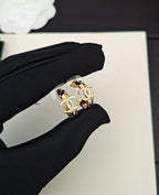 Gold-tone Chanel CC statement ring held in black fabric glove