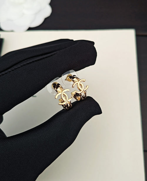 Gold-tone Chanel CC statement ring held in black fabric glove