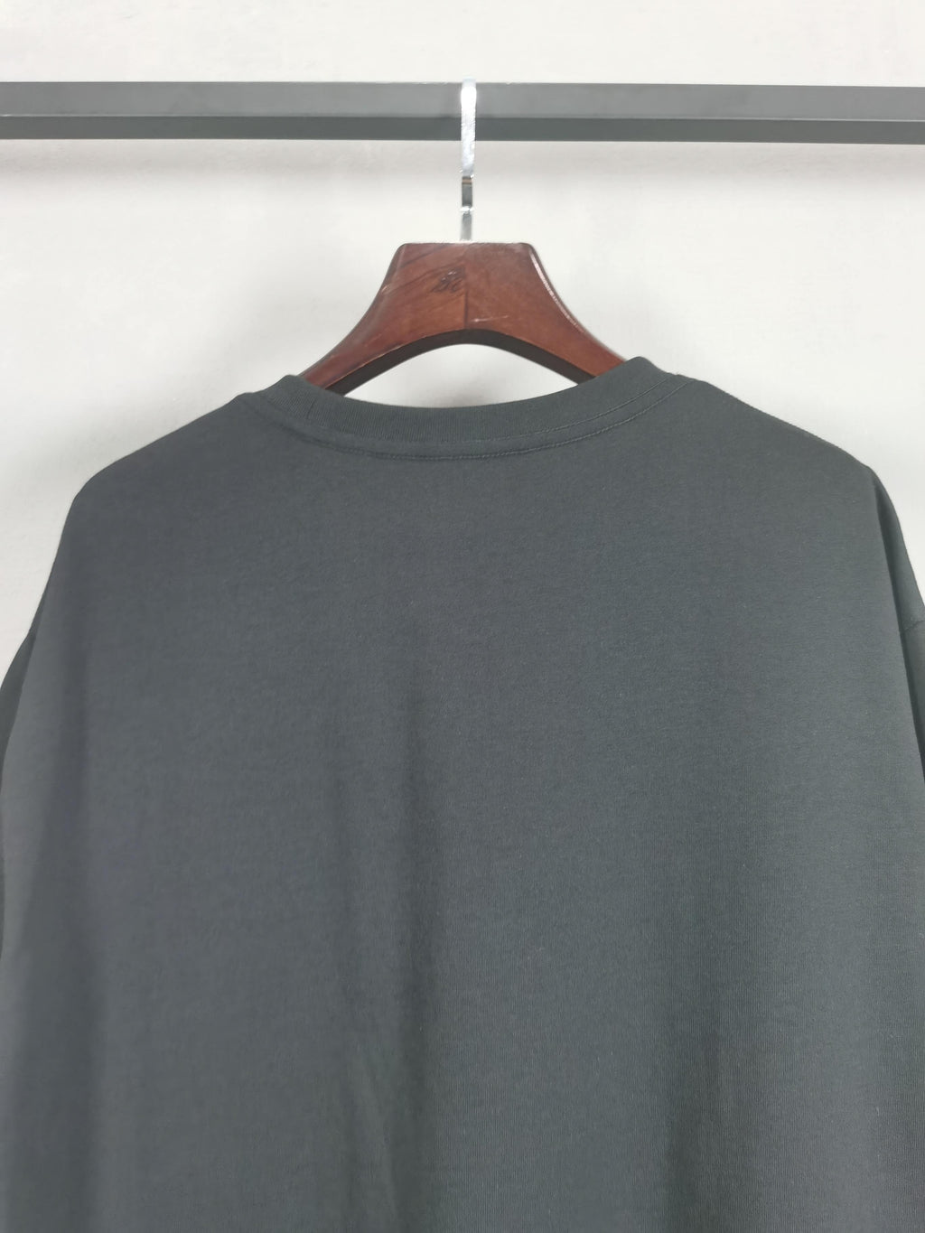 Dark crewneck T-shirt back view with round neckline, no front graphics