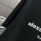 Detail view of dark black short-sleeve T-shirt sleeve and side graphic text