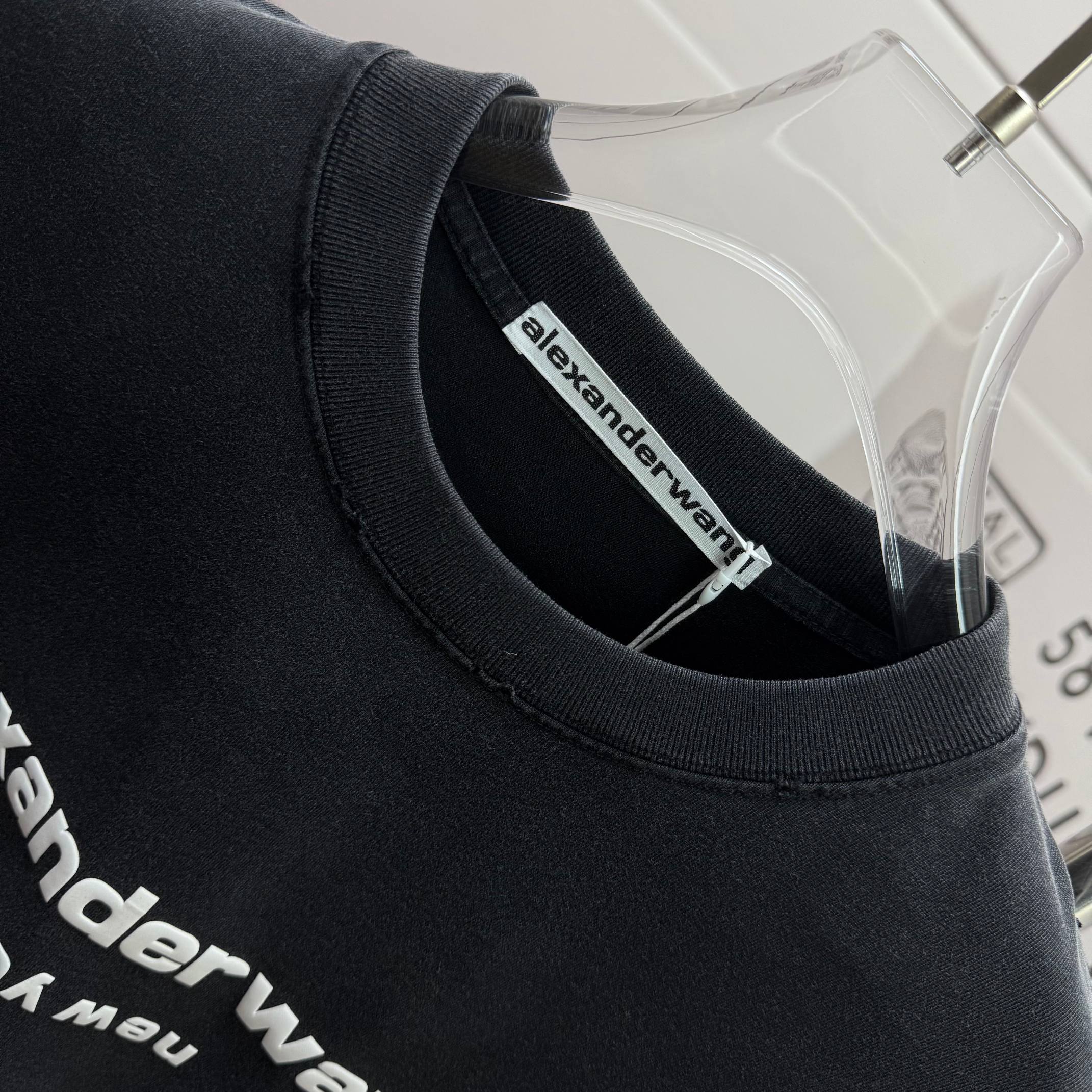 Crewneck collar of a dark black short-sleeve T-shirt with alexanderwang inside label