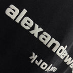 Side close-up of alexanderwang logo on a dark black short-sleeve T-shirt