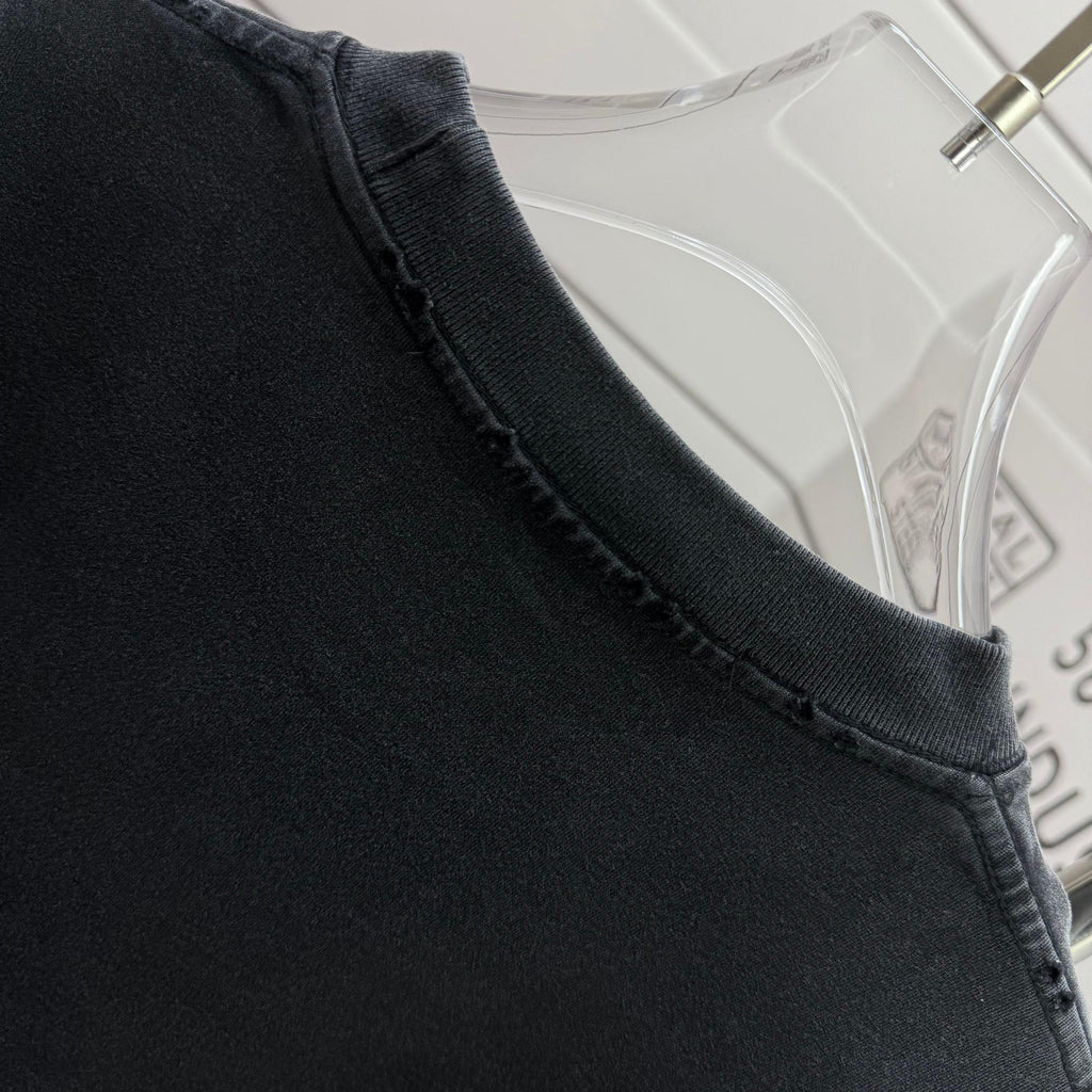 Neckline and shoulder seam of a dark black short-sleeve T-shirt