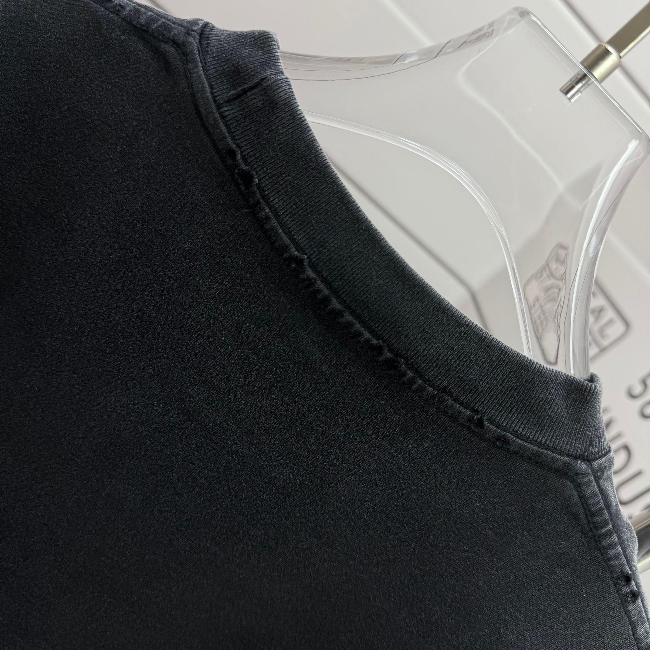 Neckline and shoulder seam of a dark black short-sleeve T-shirt