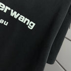 Close-up of dark black T-shirt fabric with partial alexanderwang logo lettering