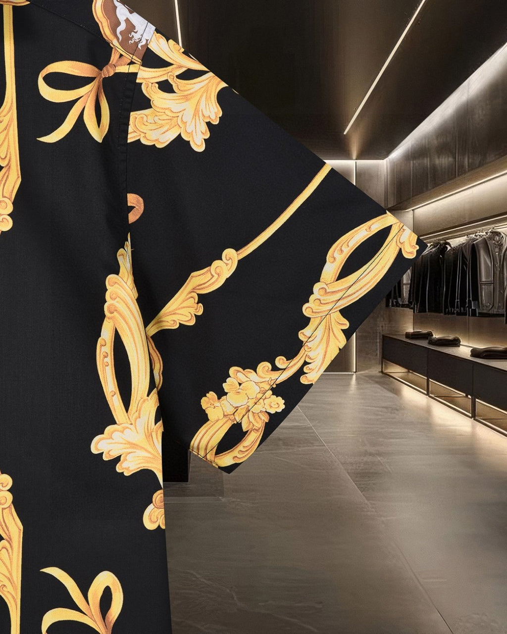 Black shirt side detail with large gold scroll pattern and ribbon-like accents