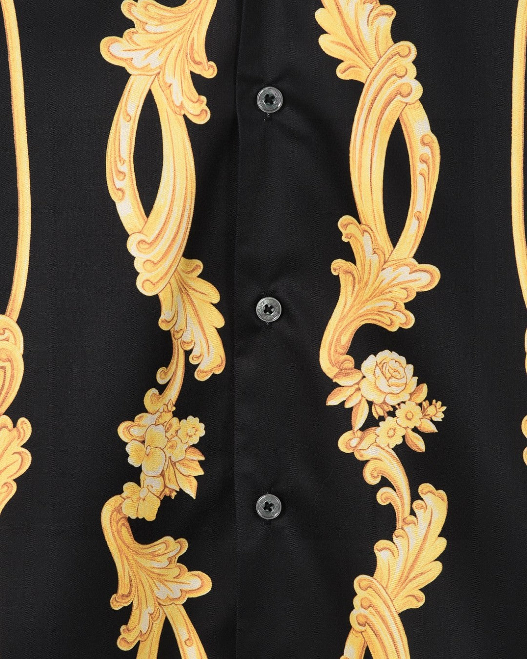Black shirt front close-up with gold floral scrolls and visible button placket