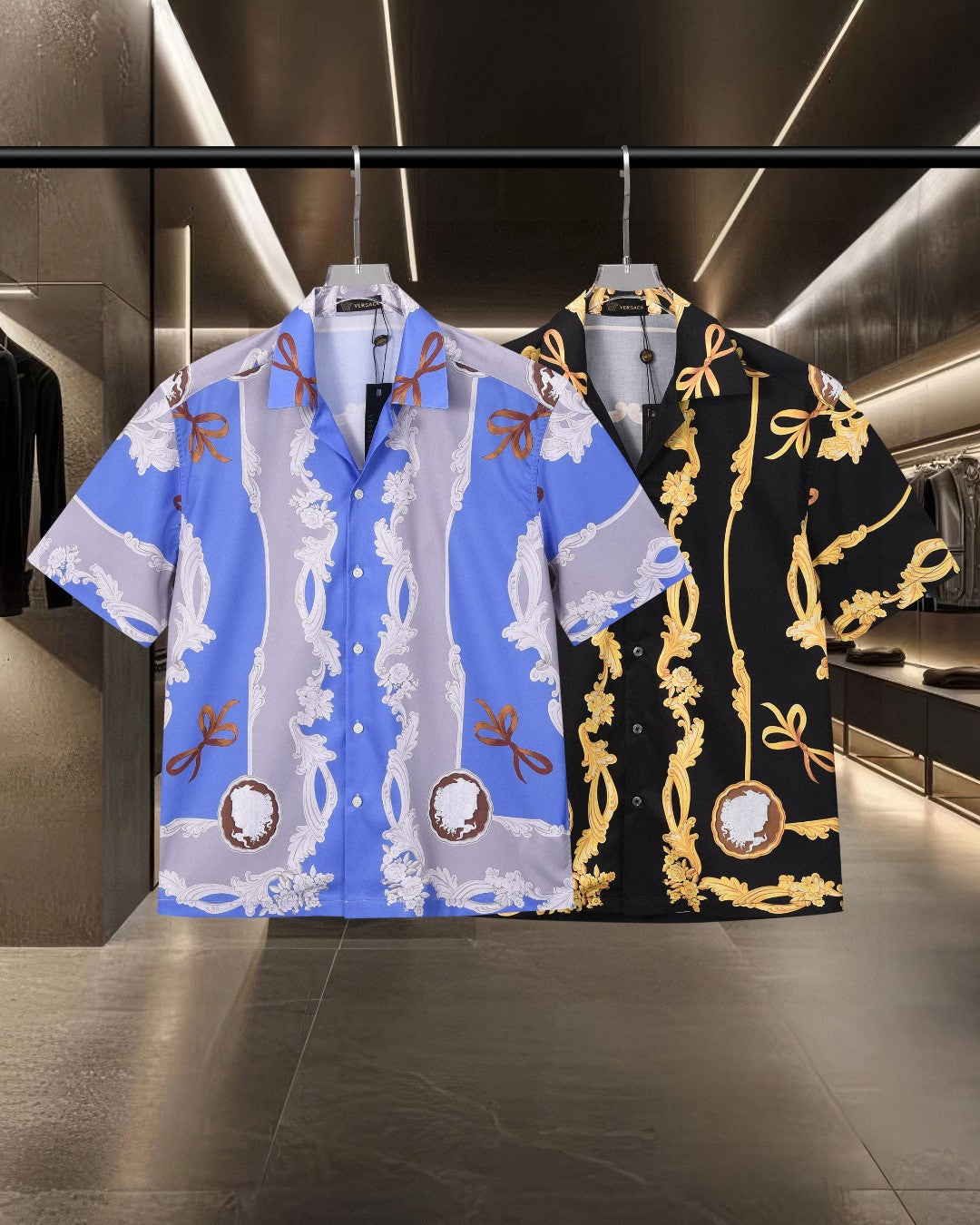 Two patterned short-sleeve button-up shirts: blue with white florals, black with gold motifs