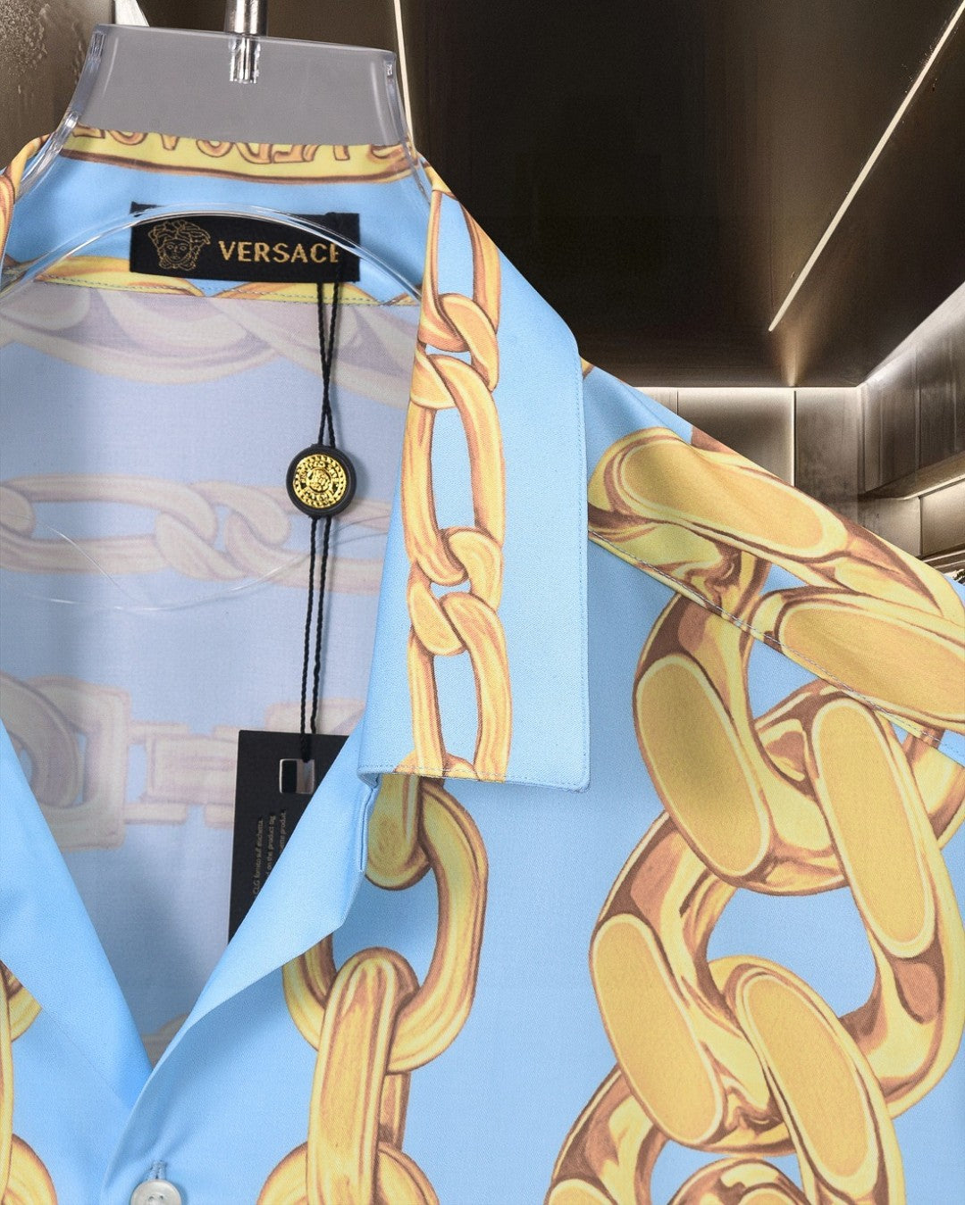 Versace short-sleeve shirt collar detail with gold chain print and black Versace tag