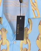 Versace clothing label on light blue shirt with gold chain print, black hanging tag