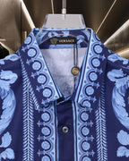 Versace blue short-sleeve shirt with button front, gold medallion, and baroque print