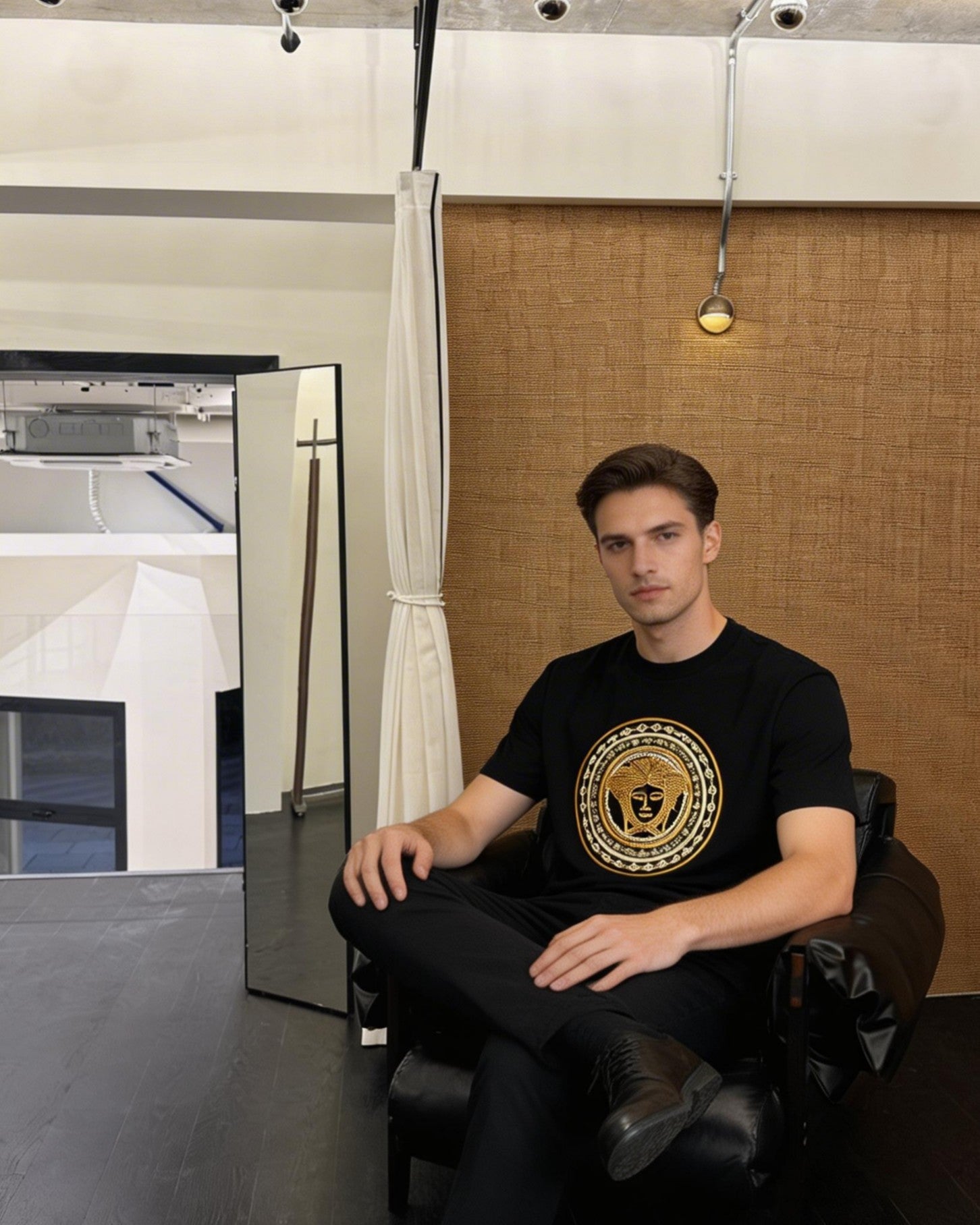 Black T-shirt with gold medallion graphic, worn by model
