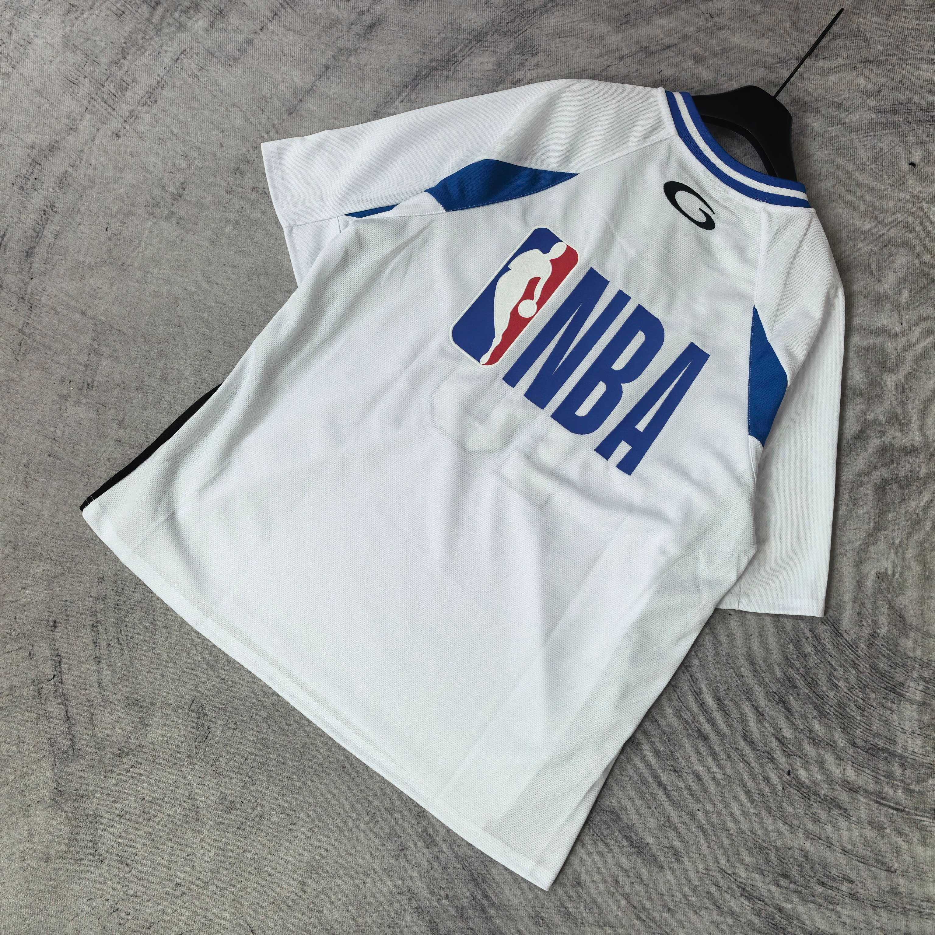 Balenciaga short-sleeve jersey laid flat, white with blue trim, “NBA” front graphic