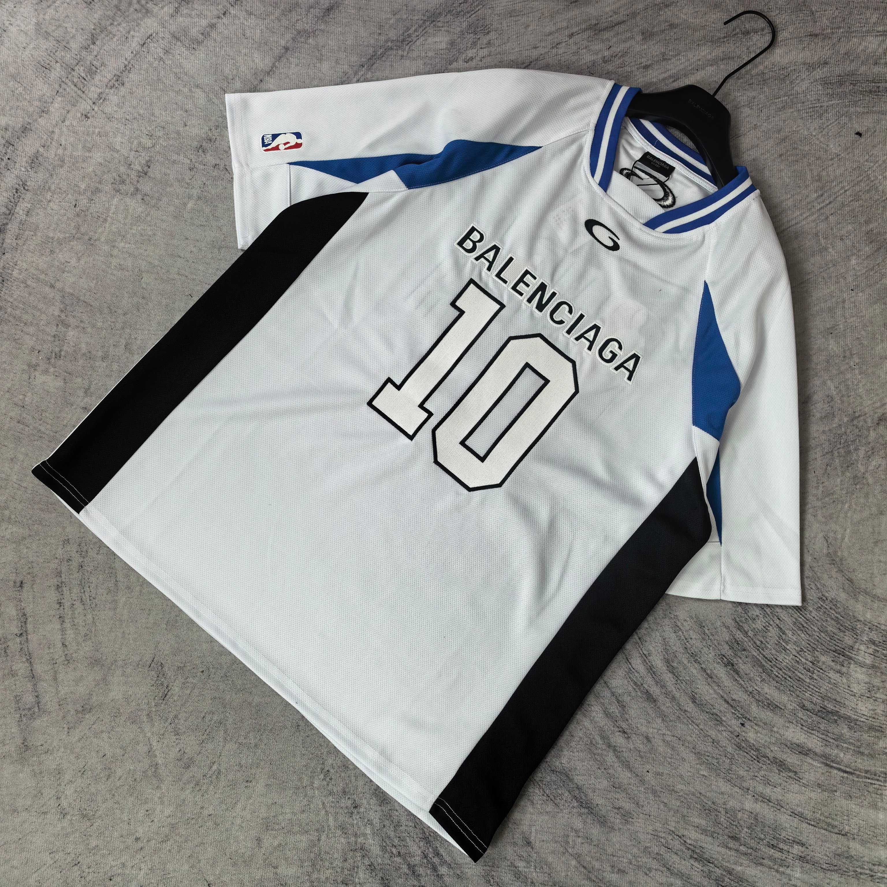 Balenciaga short-sleeve jersey laid flat, white with blue trim, “BALENCIAGA 10” front graphic